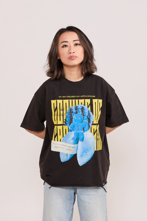 Person wearing a black t-shirt with graphic design and light blue jeans on a plain background