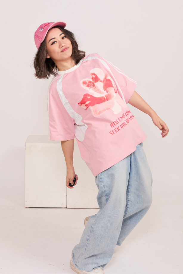 Person wearing a pink graphic t-shirt and a pink hat