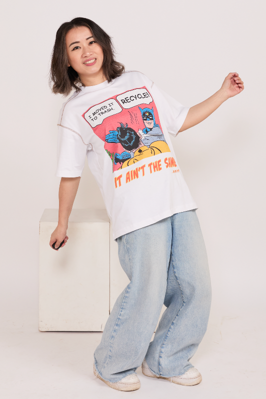 Person wearing a white t-shirt with Recycle themed graphic design and light blue jeans on a white background