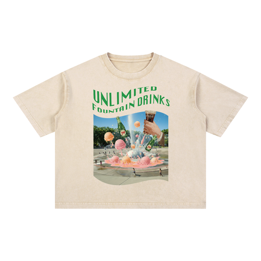 Beige t-shirt with a graphic of fountain drinks, Seattle Center fountain and 'Unlimited Fountain Drinks' text